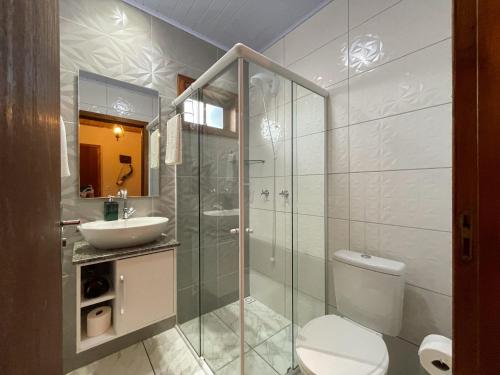 a bathroom with a shower and a toilet and a sink at Sentiero Lofts in Urubici