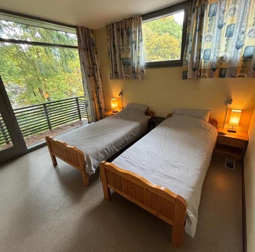two beds in a room with a window at Domaine Heyen in Waimes