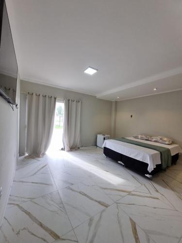a bedroom with a bed and a large window at Hotel Avalon in Benevides
