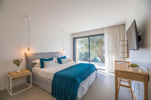 a bedroom with a bed and a large window at Casa Lilia in Olmeto