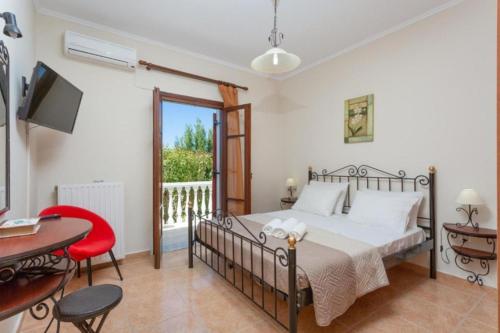 a bedroom with a bed and a table and chairs at Pothos Villas in Zakynthos