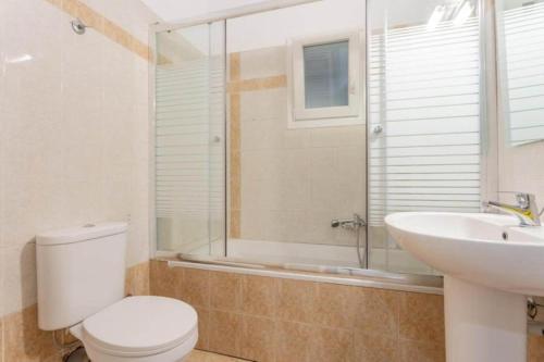 a bathroom with a toilet and a sink and a shower at Pothos Villas in Zakynthos