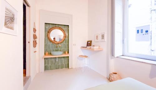 a bathroom with a mirror and a sink at OSA - Stella - Garden Hostel with bar in Naples