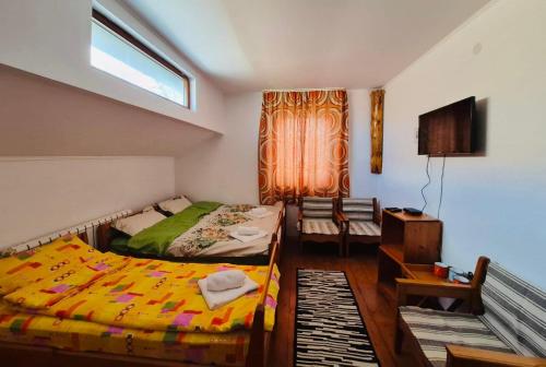a bedroom with two beds and a window at La Răscruce in Gărâna