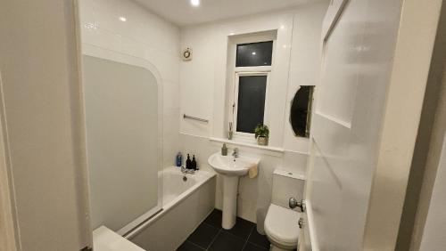 a white bathroom with a sink and a toilet at Spacious 2 Bedroom Flat in Coatbridge in Coatbridge