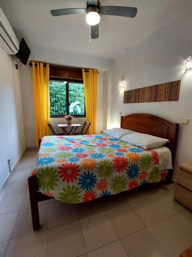 a bedroom with a bed with a colorful comforter at Residencia do Parque in Odeceixe