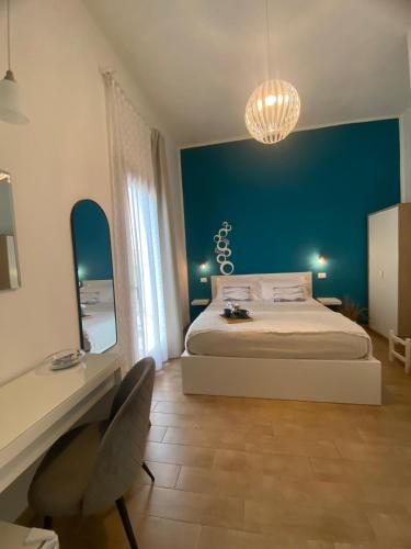 a bedroom with a bed and a blue wall at B&B La mia Isola in Castelluzzo