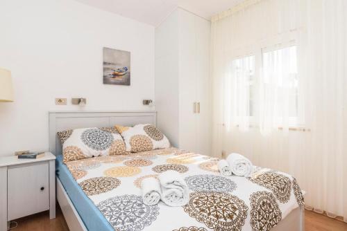 a bedroom with a bed with a comforter and pillows at House PUNTA UMAG in Umag