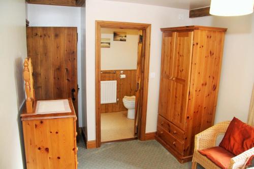 a bathroom with a toilet and a wooden door at Saddleback Barn in Penrith