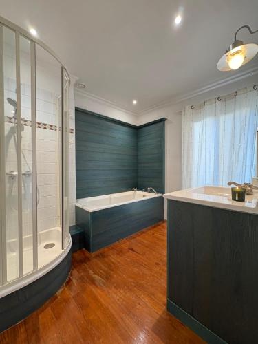 a large bathroom with a tub and a shower at La parenthèse du port in Perros-Guirec