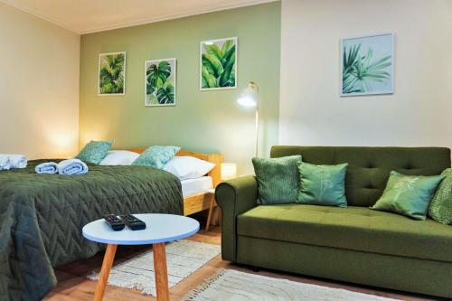 a living room with a couch and a bed at BOTANIKA apartmanok Zsálya és Rozmaring in Baja