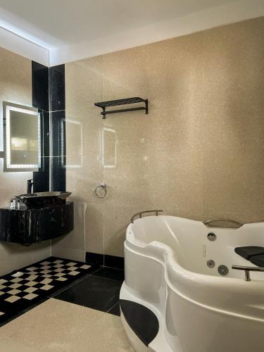 a bathroom with a white tub and a sink at Francesca Guest House in Dakar