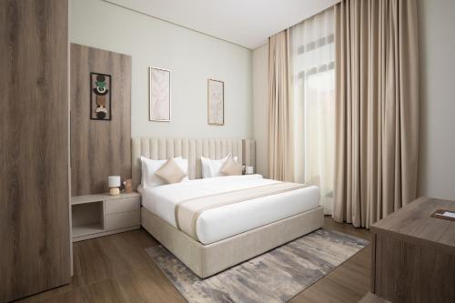 a bedroom with a large white bed and a window at Liora Al Yasmin District in Riyadh