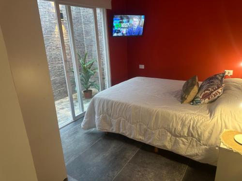 a bedroom with a bed and a tv on the wall at Aqui es 8!! in Banfield