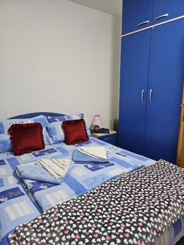 a blue bed with pillows and a blue cabinet at Apartman Ceca in Lepterija