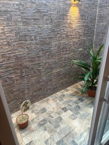 a bathroom with a tiled floor with two potted plants at Aqui es 8!! in Banfield