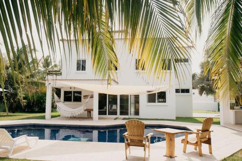 a villa with a hammock and a swimming pool at Casa La Yola in Monterrico