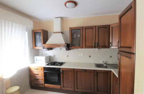 a kitchen with wooden cabinets and a stove top oven at House Casa Fabris with Pool in Umag