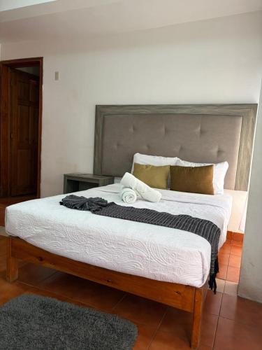 a bedroom with a large bed with white sheets at CASARU HOTEL OAXACA in Oaxaca City