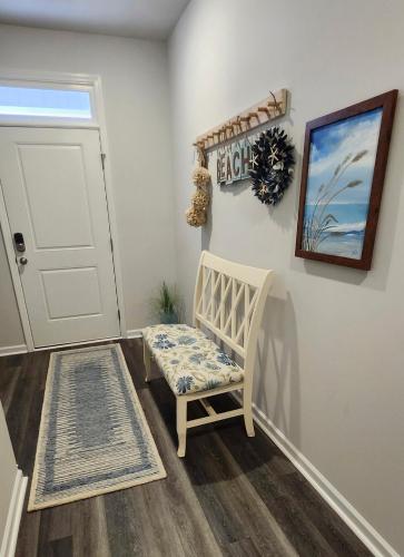 a baby room with a chair and a door at Sunset Beach townhome close to everything in Ocean Isle Beach