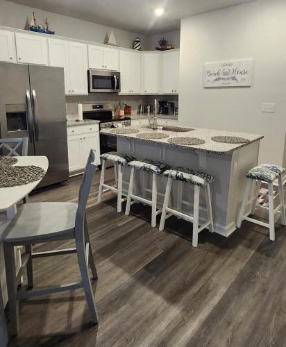 a kitchen with a large kitchen island with stools at Sunset Beach townhome close to everything in Ocean Isle Beach