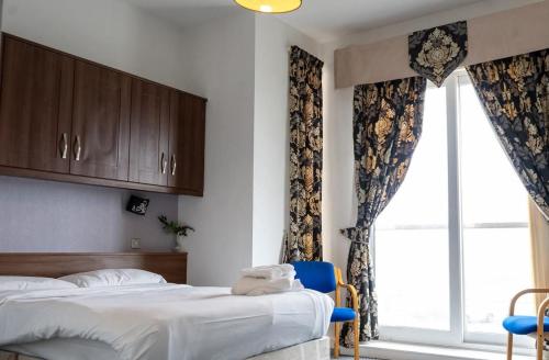 a bedroom with a bed and a large window at The Queen Vic Hotel in Monkwearmouth
