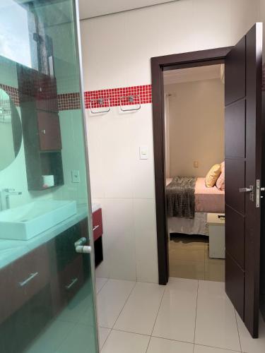 a bathroom with a shower and a sink and a bed at CASA AMPLA e MODERNA com Suíte in Porto Velho