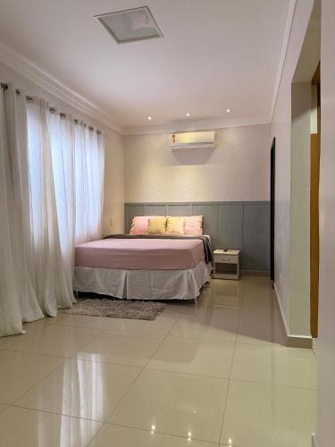 a bedroom with a bed and a window at CASA AMPLA e MODERNA com Suíte in Porto Velho
