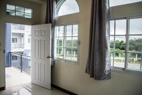 an open door in a room with windows at Plern Pitch Residence in Pak Chong