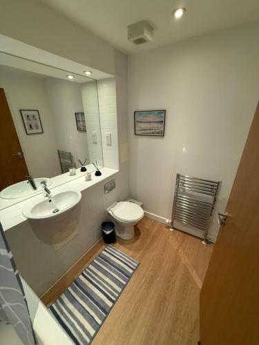 a bathroom with a sink and a toilet and a mirror at Thistle & Tide in Edinburgh