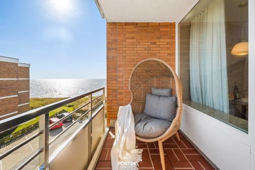 a wicker chair sitting on a balcony with the ocean at Ferienwohnung Margaritha List auf Sylt in List