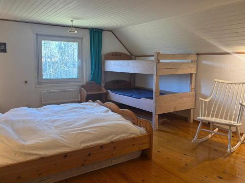 a bedroom with a bunk bed and a chair at Hus Idås in Fågelfors