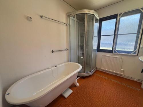 a bathroom with a bath tub and a shower at Hus Idås in Fågelfors