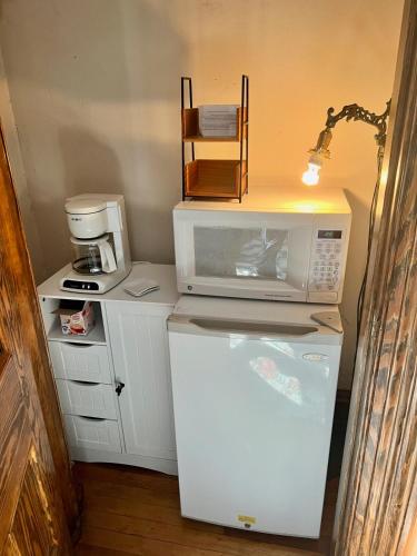a kitchen with a microwave on top of a refrigerator at Peaceful Easy Feelings - King Sized Bed - Sleeps 2 in Lynchburg