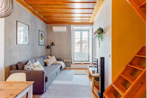 a living room with a couch and a table at Baixa Heritage Apartments by Cathedral & Tram 28 by NestAtLisbon in Lisbon
