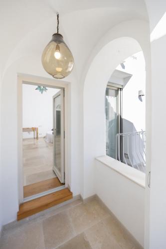 a hallway with white walls and a large mirror at Pane Amore e Magia in Anacapri