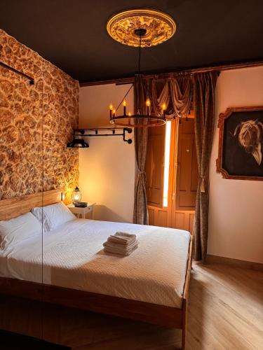 a bedroom with a bed with a stone wall at Utopía Alicante - Hotel Boutique para adultos in Alicante