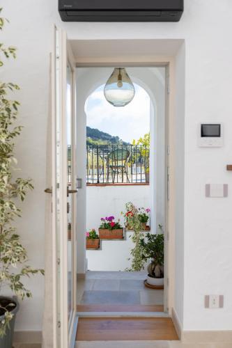 a hallway with a door leading to a balcony with potted plants at Pane Amore e Magia in Anacapri