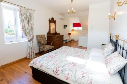 a bedroom with a bed and a chair and a window at Villa l'Orante in Lourdes