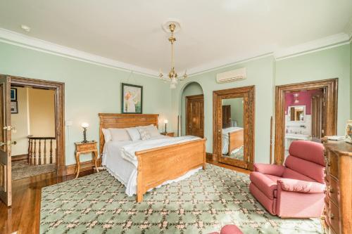 a bedroom with a bed and a pink chair at Peaceful Easy Feelings - King Sized Bed - Sleeps 2 in Lynchburg
