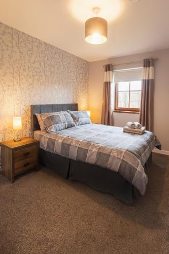 a bedroom with a large bed with a blue blanket at 3 Breckan Brae in Orkney