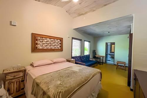 a bedroom with a large bed and a desk at Casa do Lord - Natú in Mata de Sao Joao