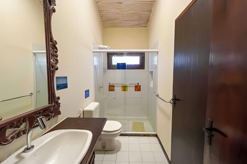 a bathroom with a sink and a toilet and a mirror at Casa do Lord - Natú in Mata de Sao Joao