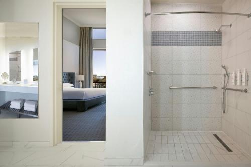 a bathroom with a shower and a bedroom at Dallas/Plano Marriott at Legacy Town Center in Plano