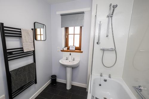 a white bathroom with a sink and a shower at 3 Breckan Brae in Orkney
