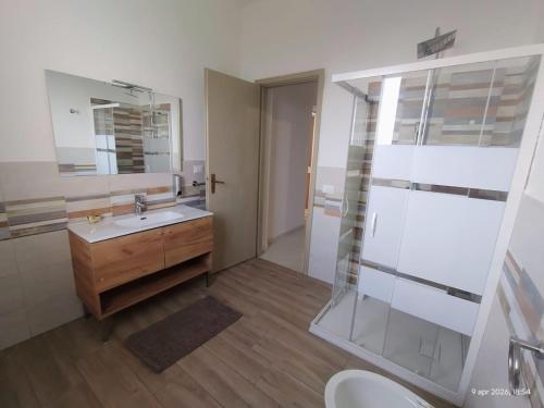 a bathroom with a sink and a mirror and a toilet at Adamo Flat in Bisciano