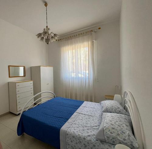 a bedroom with a blue bed and a window at Adamo Flat in Bisciano