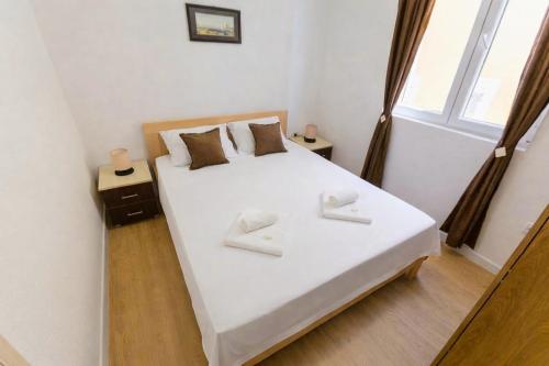 a bedroom with a large white bed with a window at Bay Horizon View in Igalo