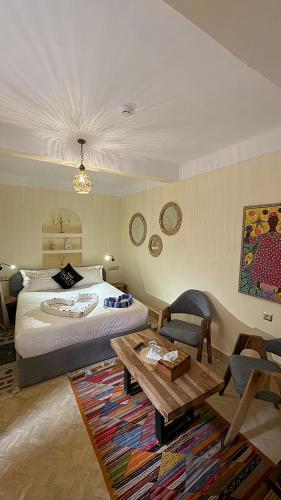 a bedroom with a bed and a table in a room at Riad Babette in Essaouira