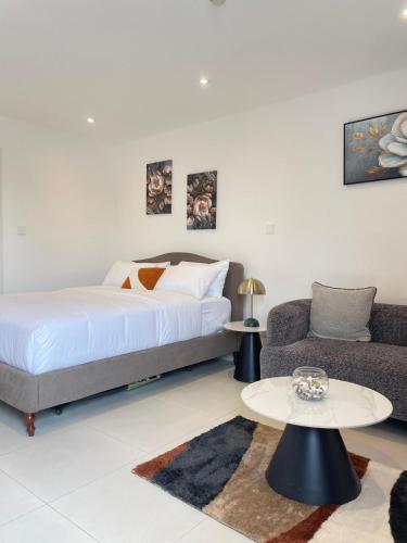 a bedroom with a bed and a couch and a table at Delali Residence at The Bantree 5 mins from Airport in Accra